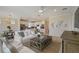 Open-concept living room with neutral decor, modern light fixture, and view into the kitchen at 2745 Serenity Meadow Dr, Kissimmee, FL 34744
