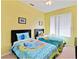 Bright bedroom with two beds, cartoon bedding, and a large window at 2918 Sunset Vista Blvd, Kissimmee, FL 34747