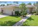 Charming single-story home featuring manicured lawn, mature landscaping, and a two-car garage at 2918 Sunset Vista Blvd, Kissimmee, FL 34747