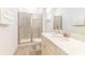 Bright bathroom featuring a glass-enclosed shower, light wood-look floors, and vanity with white countertop at 2988 Salted Rim Rd, Kissimmee, FL 34747