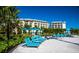 Relaxing beachfront featuring comfortable lounge chairs under cabanas, palm trees, and views of the luxurious resort buildings at 2988 Salted Rim Rd, Kissimmee, FL 34747