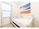 Bright bedroom featuring a twin bed with white frame, beach-themed decor, and tile floor at 2988 Salted Rim Rd, Kissimmee, FL 34747