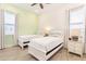 Bright bedroom with two twin beds featuring white frames, pale green accent wall, and tile floor at 2988 Salted Rim Rd, Kissimmee, FL 34747