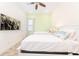 Cozy bedroom featuring a TV, two twin beds with white frames, pale green accent wall, and ceiling fan at 2988 Salted Rim Rd, Kissimmee, FL 34747
