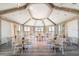 An elegant dining area features high ceilings, wood beams, and plenty of natural light with beautiful tables and chairs at 2988 Salted Rim Rd, Kissimmee, FL 34747