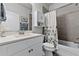 Well-lit bathroom featuring modern vanity, cabinets, and a shower/tub combo with decorative shower curtain at 3078 Isles Way, New Smyrna Beach, FL 32168