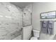 Modern bathroom featuring a stunning marble tile shower, sleek glass enclosure and minimalist design at 3078 Isles Way, New Smyrna Beach, FL 32168