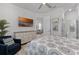Bright bedroom featuring a comfortable armchair, large dresser, TV, and an ensuite bathroom with modern finishes at 3078 Isles Way, New Smyrna Beach, FL 32168