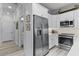 Bright kitchen showcasing stainless steel refrigerator and white shaker-style cabinets at 3078 Isles Way, New Smyrna Beach, FL 32168