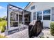 A screened in patio features pavers, a grill and access to both the house and the yard at 3078 Isles Way, New Smyrna Beach, FL 32168