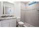 Modern bathroom with granite countertop, white cabinets, and tiled walk-in shower with mosaic accents at 3242 Viceroy Ct, Poinciana, FL 34759