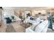 Bright open-concept living room with hardwood floors connecting kitchen and staircase at 3242 Viceroy Ct, Poinciana, FL 34759