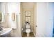Cozy powder room with neutral colors, decorative wall art and wood look floors at 3242 Viceroy Ct, Poinciana, FL 34759
