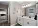 Bright bathroom featuring a double vanity, decorative accents, and an open doorway to another room at 3332 Lone Cypress Pt, Oviedo, FL 32765