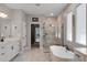 A contemporary bathroom features a freestanding tub, a glass shower, and a double vanity with modern fixtures at 3332 Lone Cypress Pt, Oviedo, FL 32765