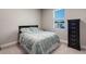 A cozy bedroom featuring a comfortable bed with matching bedding and a dark wood dresser by a window at 3332 Lone Cypress Pt, Oviedo, FL 32765