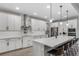 Bright kitchen with stainless steel appliances, white cabinets, quartz counters and seating at the island at 3332 Lone Cypress Pt, Oviedo, FL 32765