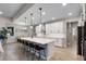 Open kitchen with white cabinets, large island with barstool seating, and stainless steel appliances at 3332 Lone Cypress Pt, Oviedo, FL 32765