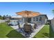 Backyard oasis with a sparkling pool, outdoor kitchen, patio dining, and lush green space for outdoor entertainment at 3332 Lone Cypress Pt, Oviedo, FL 32765