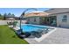 Backyard oasis featuring a sparkling pool with a sun shelf, outdoor kitchen, and lounge chairs for relaxation at 3332 Lone Cypress Pt, Oviedo, FL 32765