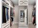 Organized walk-in closet with custom shelving, a full-length mirror, and an open doorway leading to another room at 3332 Lone Cypress Pt, Oviedo, FL 32765