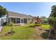 Backyard with green grass, playset, and view of the house's screened in porch at 342 Hanging Moss Cir, Lake Mary, FL 32746