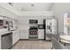 Bright kitchen features stainless steel appliances, tile floors, sleek white cabinets, and eat-in breakfast nook at 342 Hanging Moss Cir, Lake Mary, FL 32746