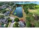 A neighborhood aerial view features a pond surrounded by well-maintained homes and lush trees on a sunny day at 3562 Gatlin Pl, Orlando, FL 32812