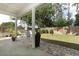 Paved backyard patio with furniture, with a lush lawn and wooded perimeter at 3562 Gatlin Pl, Orlando, FL 32812