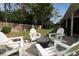 Paver patio with fire pit surrounded by chairs in a grassy backyard with wooden fence at 3562 Gatlin Pl, Orlando, FL 32812