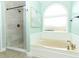 Bright bathroom features a separate tiled shower, soaking tub, and decorative window at 3562 Gatlin Pl, Orlando, FL 32812