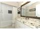 Bright bathroom featuring white cabinets, granite countertops, and tiled shower-tub combo at 3562 Gatlin Pl, Orlando, FL 32812