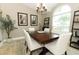 Elegant dining area with a dark wood table, white chairs, and an abundance of natural light at 3562 Gatlin Pl, Orlando, FL 32812