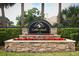 Stone community sign for Gatlin Place with colorful flowerbeds and lush palm trees at 3562 Gatlin Pl, Orlando, FL 32812