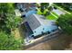 Aerial view of a light blue home with gray roof, fenced yard, stone patio and lush landscaping at 3562 Gatlin Pl, Orlando, FL 32812