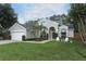 Attractive home with lush green lawn, palm trees, and a two-car garage, offering curb appeal at 3562 Gatlin Pl, Orlando, FL 32812