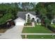 Charming home with manicured lawn, mature trees, arched windows, and a two-car garage at 3562 Gatlin Pl, Orlando, FL 32812