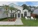 Charming home featuring well-manicured landscaping, palm trees, and a welcoming front porch with seating at 3562 Gatlin Pl, Orlando, FL 32812