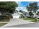 Charming home exterior with a two-car garage, palm trees, and a well-manicured lawn at 3562 Gatlin Pl, Orlando, FL 32812