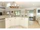 Bright and airy kitchen showcasing white cabinetry, granite countertops, and a view to the outside patio at 3562 Gatlin Pl, Orlando, FL 32812