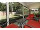 Inviting screened porch featuring red patio furniture with views of the backyard and trampoline at 3562 Gatlin Pl, Orlando, FL 32812