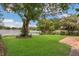 Serene backyard with a lush lawn, mature trees, and stunning lake view, creating a peaceful retreat at 3605 Pershing Ave, Orlando, FL 32812