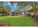 Well-maintained backyard featuring a lush lawn, mature trees, screened in porch and brick patio at 3605 Pershing Ave, Orlando, FL 32812
