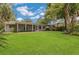 A sprawling backyard features lush green grass and a screened-in porch, perfect for outdoor enjoyment at 3605 Pershing Ave, Orlando, FL 32812