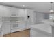 Bright kitchen features white cabinetry, appliances, and countertops, plus wood flooring at 3605 Pershing Ave, Orlando, FL 32812