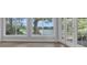 Bright living room featuring hardwood floors and a beautiful lake view through the expansive windows and glass patio doors at 3605 Pershing Ave, Orlando, FL 32812
