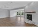 Bright and open living room featuring hardwood floors, a white brick fireplace, and large windows at 3605 Pershing Ave, Orlando, FL 32812
