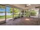Large screened in porch overlooking the yard and lake with a brick floor and ceiling fan at 3605 Pershing Ave, Orlando, FL 32812