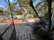 Backyard showcasing a stone paver path, gravel landscaping, and mature trees at 3807 Atrium Dr, Orlando, FL 32822