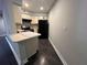 Compact kitchen featuring modern appliances, a breakfast bar, and ample counter space at 3807 Atrium Dr, Orlando, FL 32822